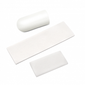 Three white graft accessory shapes shown together: a rounded plug, a long tape strip, and a small rectangular pad.
