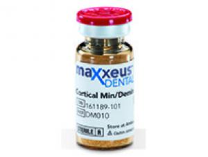 A glass vial with a red flip-top cap containing tan granular bone particulate, labeled Maxxeus Dental Cortical Min/Demin.